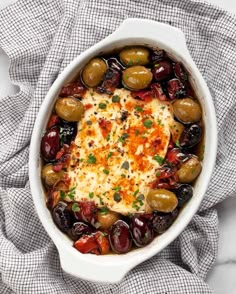 an oval casserole dish filled with olives and cheese