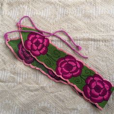 a close up of a piece of cloth with flowers on it and pink thread in the middle