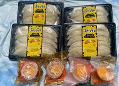 four packaged food items sitting on top of a blue cloth covered tablecloth in plastic bags