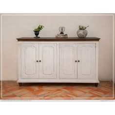 a white cabinet with two pots on top and one potted plant sitting on top