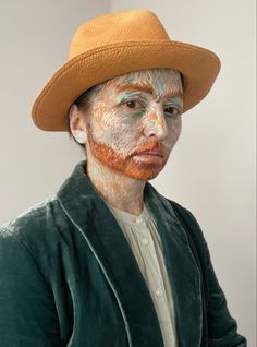 a woman with face paint and a hat on