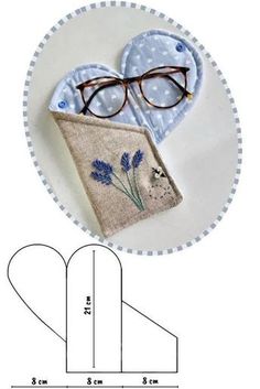 a pair of glasses sitting on top of a piece of fabric next to a ruler