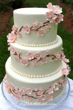 a wedding cake decorated with pink flowers and pearls