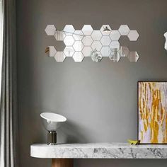 a bathroom with marble counter tops and mirrors on the wall, along with an art piece