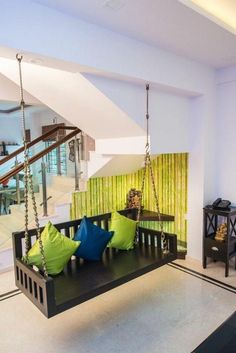 a living room filled with furniture next to a stair case and green wall coverings