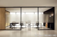 an empty conference room with glass walls and sliding doors on the wall, along with black chairs