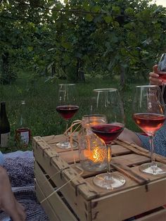 a woman sitting at a table filled with wine glasses