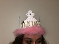 a woman wearing a pink and gold crown