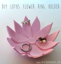 a pink flower ring holder with two rings on it