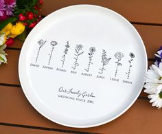 a white plate with flowers on it and the names of five different families engraved on it