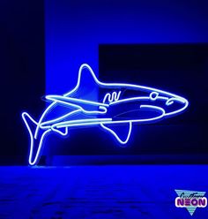 a neon shark is shown in the dark