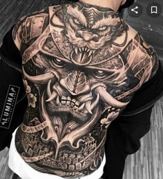 the back of a man's body covered in tattoos