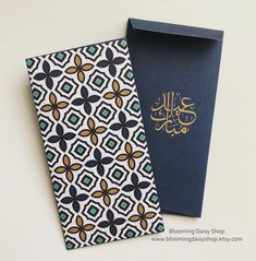 two cards with arabic calligraphy on them, one is blue and the other is gold