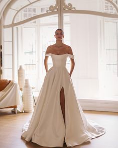 a woman in a white wedding dress posing for the camera