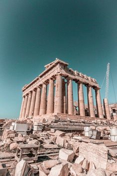 the ruins of an ancient greek temple are seen against a blue sky