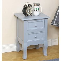 a blue nightstand with two drawers and an alarm clock