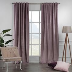 a living room filled with furniture and a window covered in purple drapes next to a chair