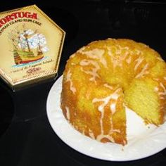 a bunt cake sitting on top of a white plate next to a box of honey