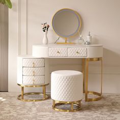 a white vanity table with two stools and a round mirror