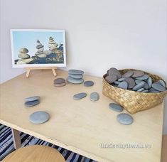 a table with rocks on it and a basket full of stones in front of it