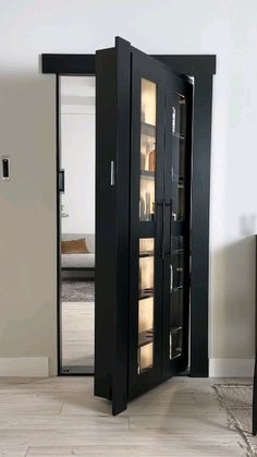 a tall black cabinet with glass doors in a room