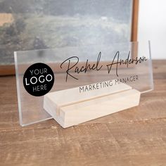 a clear acrylic business card holder sitting on top of a wooden table