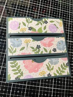 two card holders sitting on top of a table next to each other with floral designs