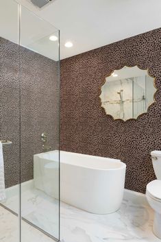 a bathroom with a white tub sitting next to a walk in shower and a toilet