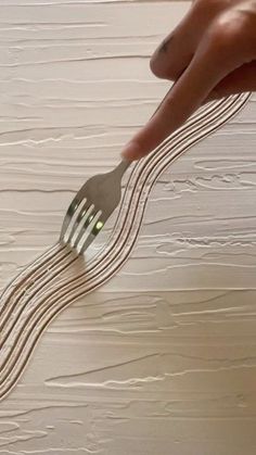 a person holding a fork and pointing it at something on the ground with lines coming out of it