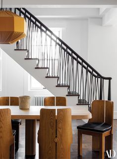 a dining room table and chairs under a stair case