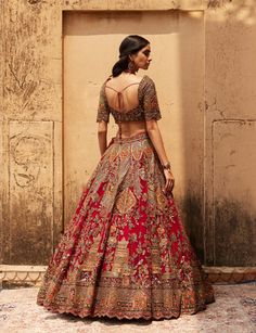 Showcasing here is the scarlet lehenga set based on net where jewelled hues like deep maroon and golden dance in perfect harmony. The craftsmen have showcased their utter dedication in this magnifi... Golden Bridal Lehenga, Indian Bridal Wear Red, Red Wedding Lehenga, Sabyasachi Lehenga Bridal, Black Tie Outfits, Lehenga Designs Simple