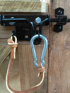 a close up of a horse bit on a wooden door with a harness hanging from it's side