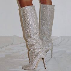 These boots feature a pointy toe design which gives them an edgy yet classy look. The whole shoe is adorned with sparkling rhinestones, making it the perfect party accessory. Fashioned with stiletto heels, they add an instant height boost while maintaining a comfortable fit. Crafted from durable materials, these boots are designed to last. Whether you're heading to a party or a high-profile business meeting, these fashion-forward boots will make a statement. Elevate your wardrobe with their alluring charm and versatile elegance. Style: knee high boots Color: silver Heel Height: 12 cm Heel Type: stiletto heel Toe: pointy toe Platform: without platform Gender: female Occasion: work/ formal event/ date/ anniversary/ music festival/ school/ going out/ hanging out/ traveling/ honeymoon/ red car Demonia Boots, Pointed Boots, Womens High Boots, Mv Outfits, Rhinestone High Heels, Rhinestone Shoes, Tour Outfits, Stiletto Boots, Slip On Boots