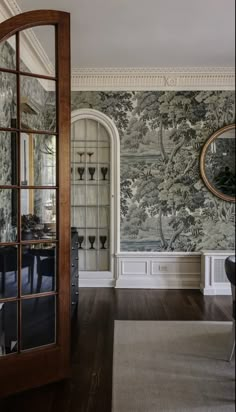 a room with a large mirror and wallpaper