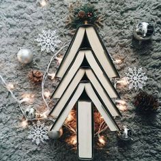 a christmas tree made out of books on top of a carpet with lights and ornaments around it