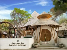 the entrance to fala lanna spa is made out of bamboo and has two benches on each side