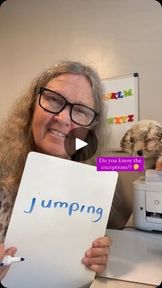 a woman holding up a sign with the word jumping written on it