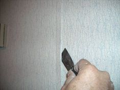 a person holding a knife in their left hand and pointing it at something on the wall