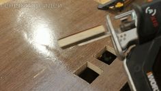 a drill is sitting on top of a piece of wood next to a hole in the floor