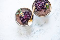 two bowls filled with food on top of a white counter next to a wooden spoon