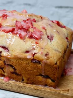 a loaf of strawberry bread sitting on top of a wooden cutting board