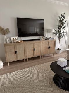 a living room with a large flat screen tv on top of a wooden entertainment center