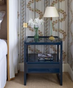 a blue table with a lamp and flowers on it