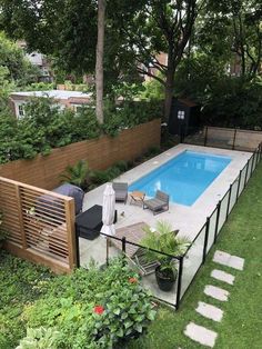 a backyard with a swimming pool surrounded by greenery