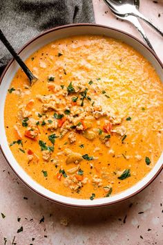 a white bowl filled with soup next to a spoon