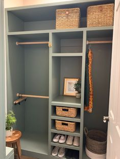 a walk in closet with baskets and clothes