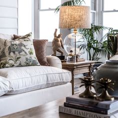 a living room filled with lots of furniture and pillows on top of a wooden table