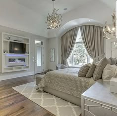 a large bed sitting in the middle of a bedroom next to a window