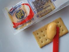 a cracker and cheese dip on a white surface next to a package of crackers