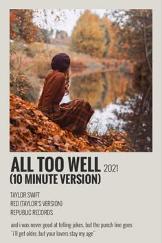 a woman sitting on the ground in front of a pond with autumn leaves around her